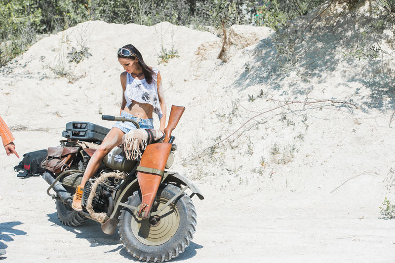 沙漠背景下性感的摩托车女郎