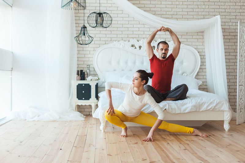 运动型健康的已婚夫妇早上做体操。