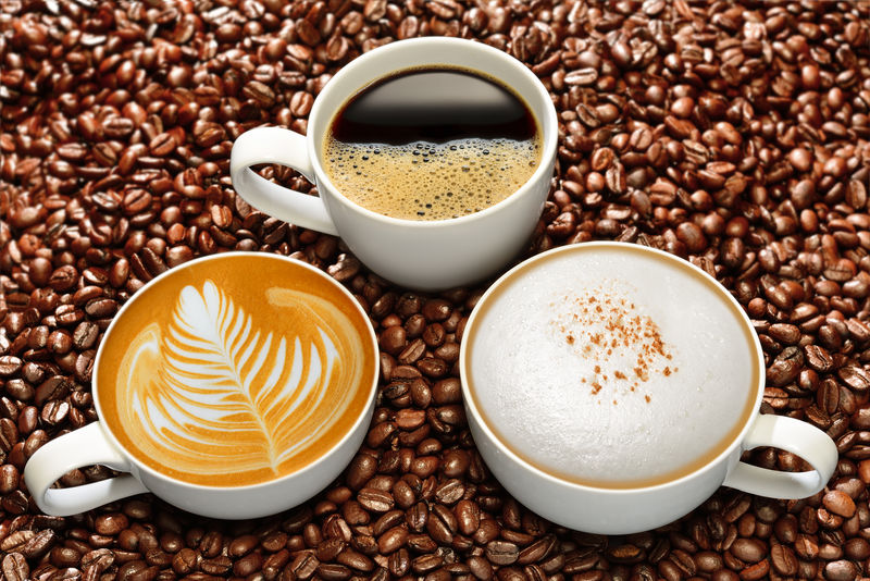 咖啡豆背景上的各种咖啡杯