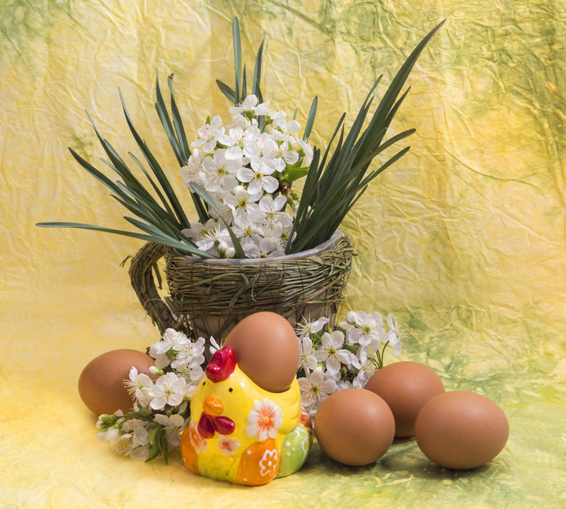 黄色背景下的鸡蛋和春天的花朵