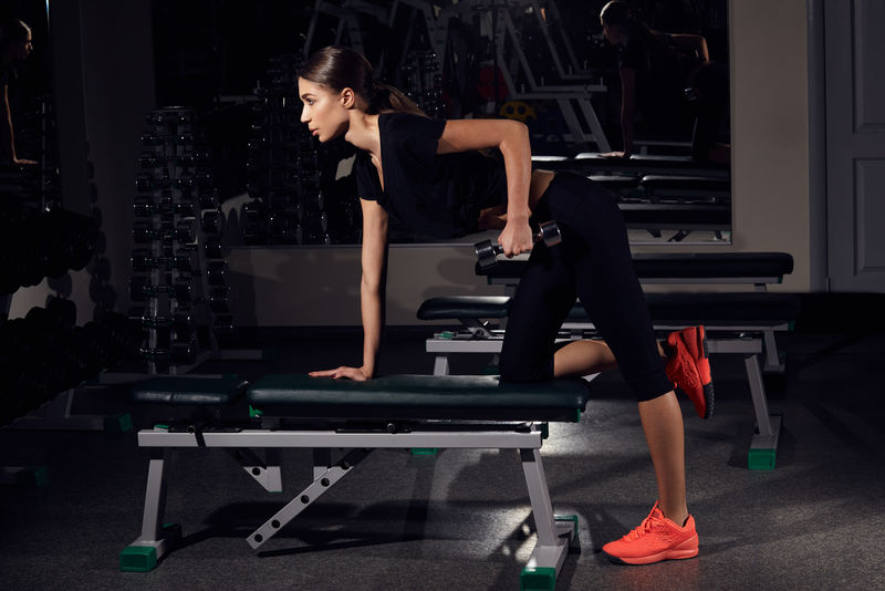 健身女性在健身房用哑铃锻炼肌肉