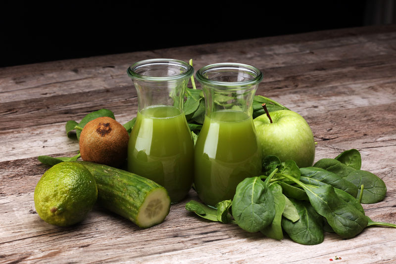 绿色排毒冰沙或由黄瓜、苹果、猕猴桃、芹菜、欧芹和Chia在木制背景上制成的奶昔