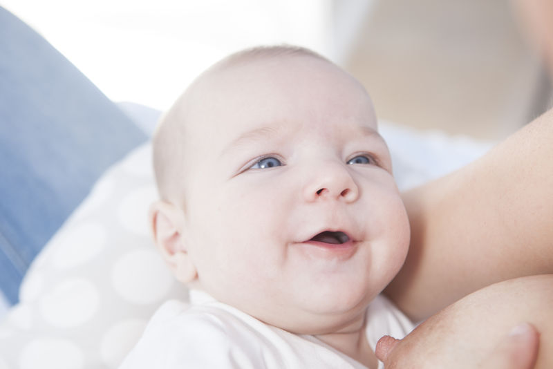 母乳喂养时微笑的婴儿