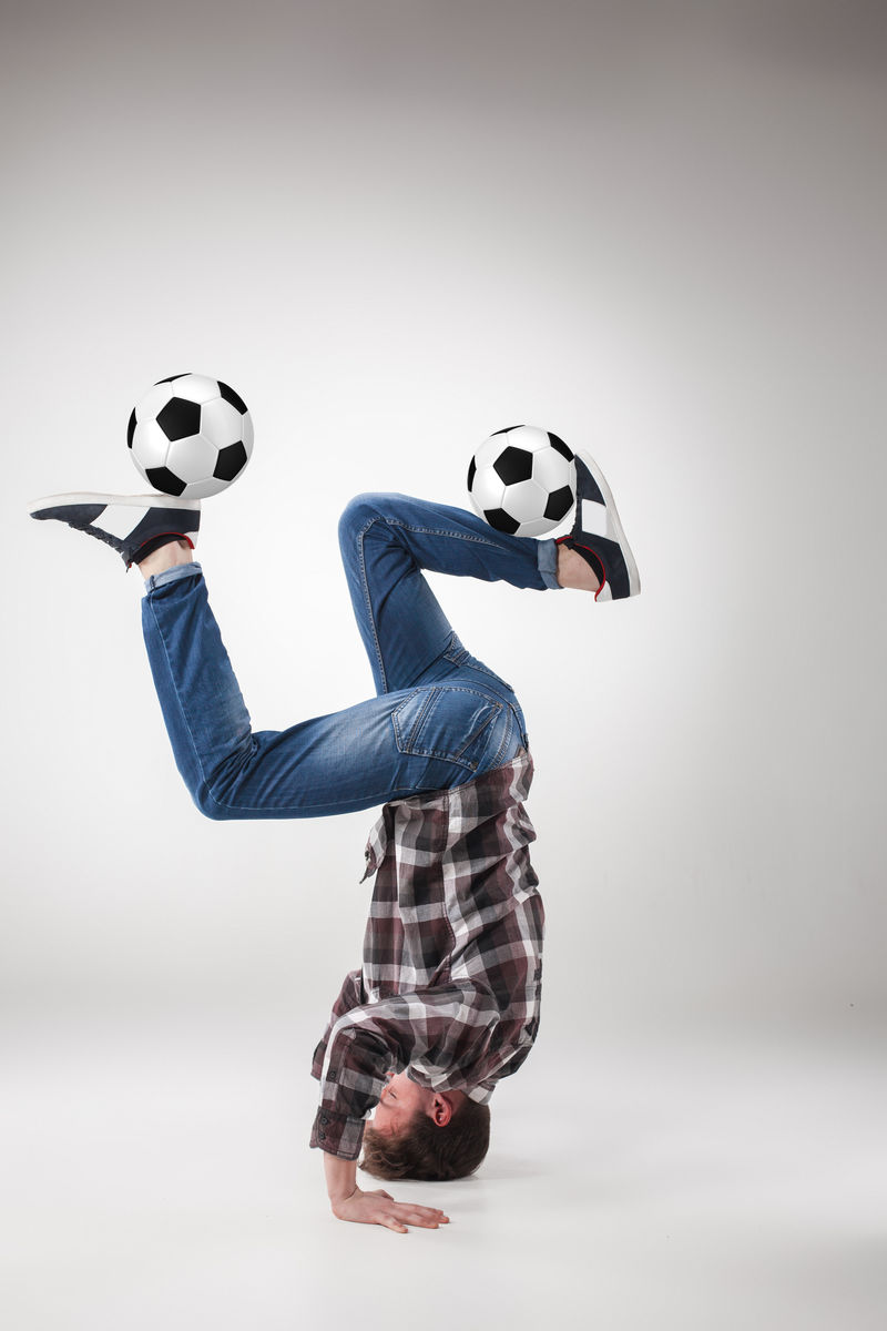年轻人的画像，用足球练习瑜伽