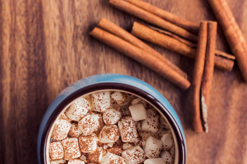 杯子里的棉花糖可可和桌子上的肉桂