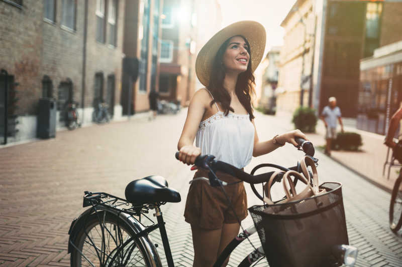 在街上骑自行车的年轻带帽女人