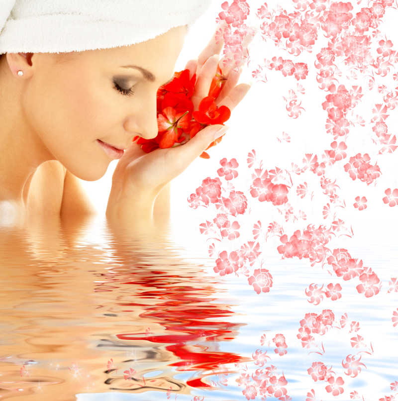在水中的可爱的女人带着红色的花瓣