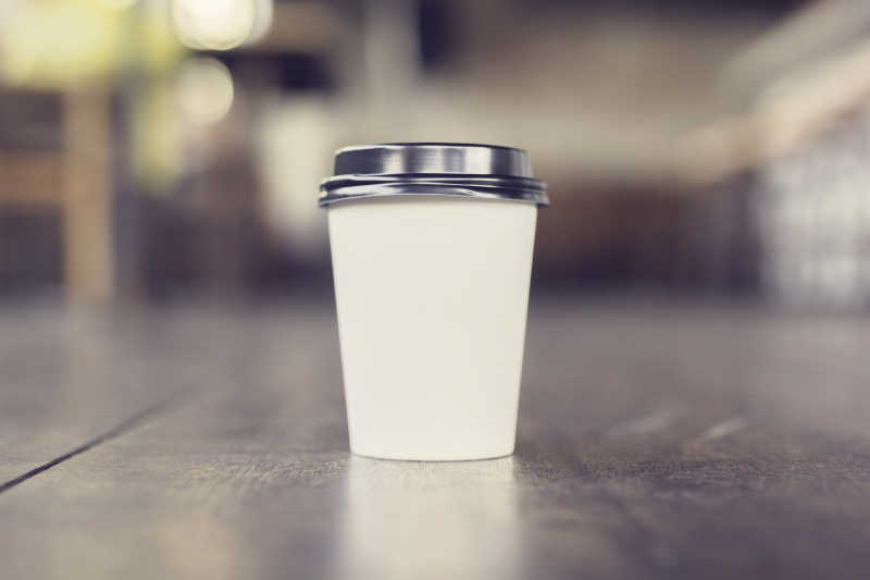 木制地板上的一杯白色咖啡杯