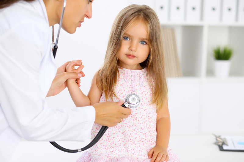 医生用听诊器检查一个小女孩