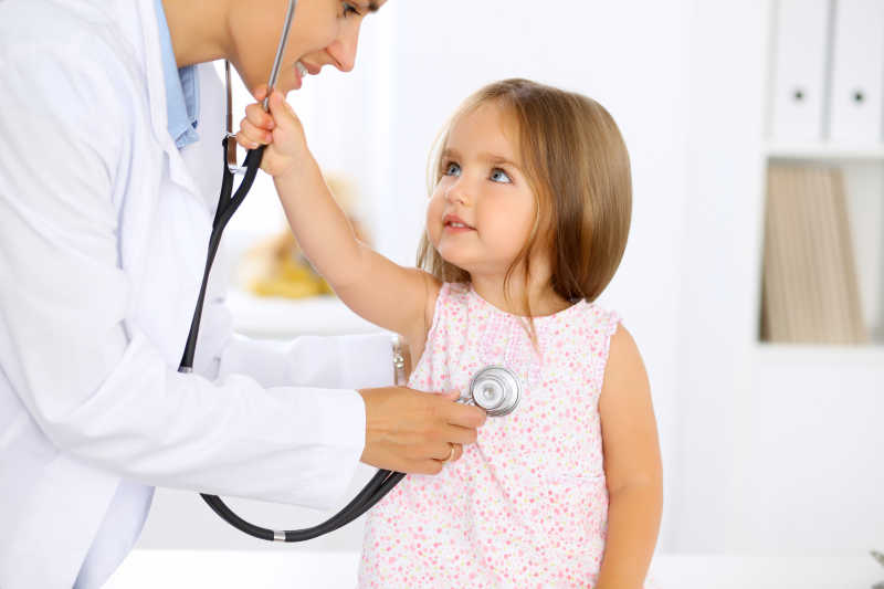 美女医生用听诊器检查一个小女孩