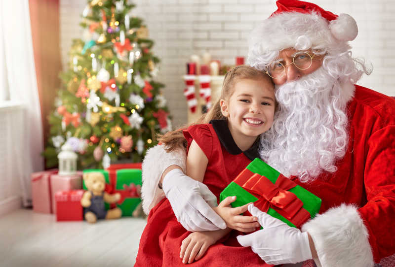 圣诞老人抱着微笑的小女孩