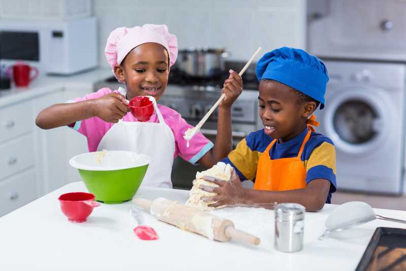厨房里准备蛋糕的两个非洲儿童