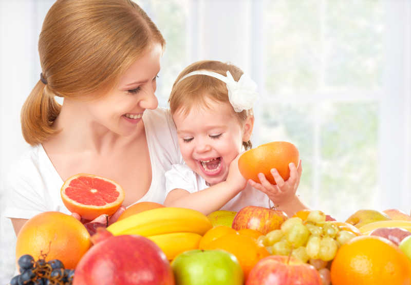幸福家庭母亲和女儿吃健康水果