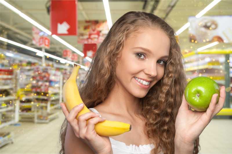 超市里选苹果香蕉的美女