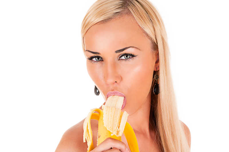 白色背景中的金发美女吃香蕉
