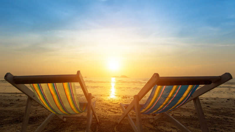 海滩上日落下的两张沙滩椅