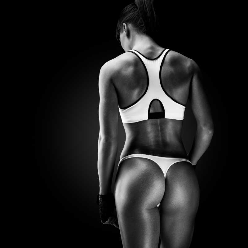 黑色背景中健身女子的肌肉背部