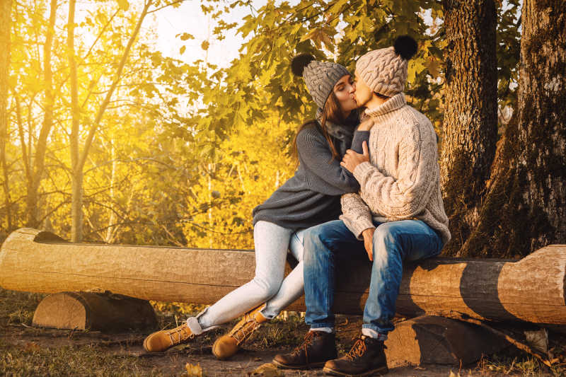阳光明媚的秋天公园里的情侣在亲吻