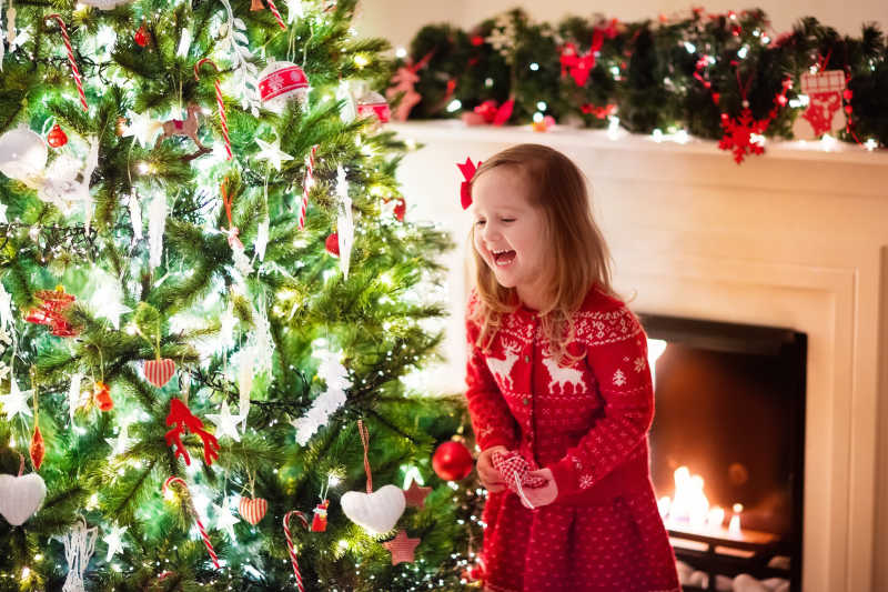 装饰圣诞树的开心小女孩