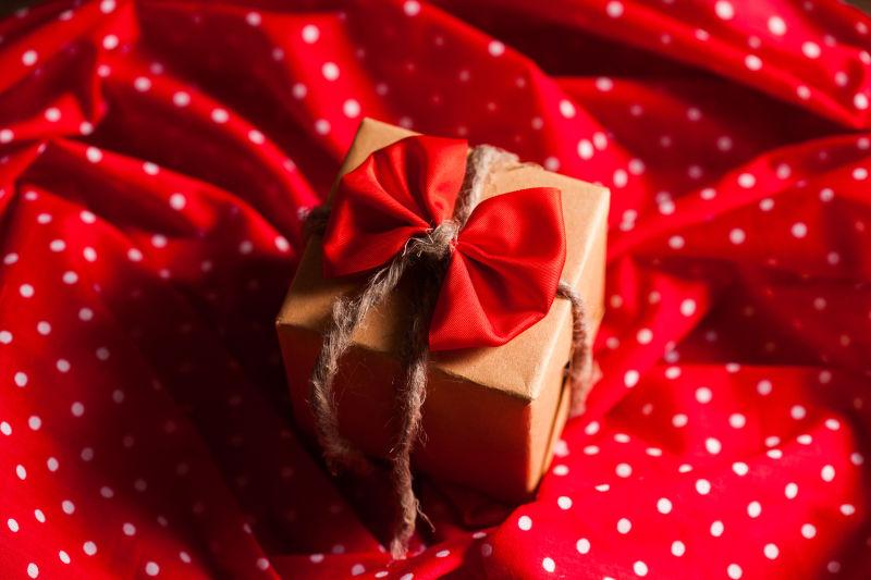 红丝绸上的圣诞节红色礼品盒