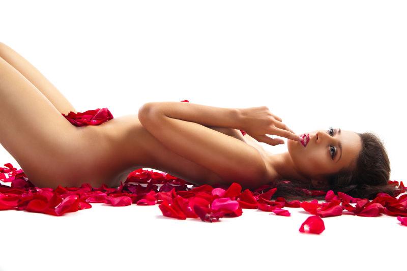 性感的美女躺在玫瑰花瓣上