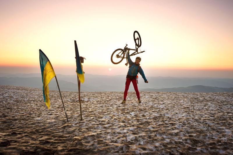 极限自行车运动员在日出下举着自行车