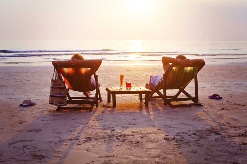 夕阳下海滩躺椅上的两个人
